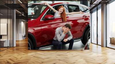 Dreams come true. Red-haired young woman feeling extreme degree of ecstasy and happiness when her boyfriend presented her a new luxury car. Positive emotions, Auto Business , Car Selling Wall mural