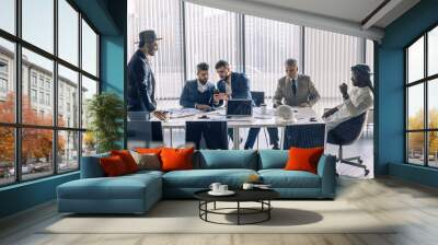 Elegant well-dressed business men of different age and ethnicity in suits gathered together for negotiating, collaborating in spacious modern office meeting room Wall mural