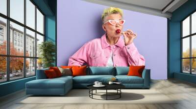 funny woman with dyed yellow hairstyle enjoying eating sweets, sweet tooth, happiness, favourite candy Wall mural