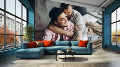 Gay couple in love flirting and having fun, enjoying every minute spent together, embracing and whispering in his ear sweet words Wall mural