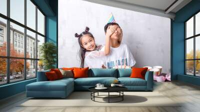 happy girl closing the eyes of his brother during the party indoors. copy space. friendship concept. feeling Wall mural