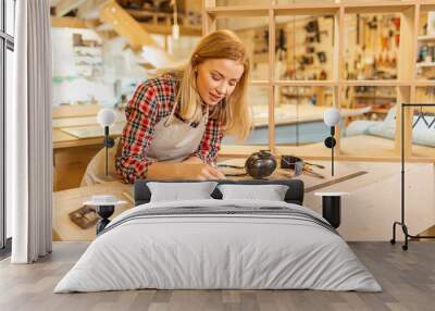 hardworking caucasian woman woodworker make drawings, young lady loves her job in factory Wall mural