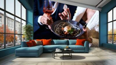 High european cuisine. People eat sweet dessert from beautiful dish and drink red champagne. Restaurant concept Wall mural