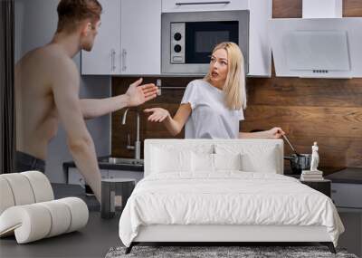 man asks his wife to cook a variety of dishes, wife aggresses on this. man dissatisfied with family life, shirtless guy and blonde female argue Wall mural