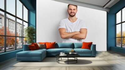 man in stylish T- shirt standing with crossed arms isolated on white background. close up portrait. sportsman having rest, personal trainer looking at the camera, waiting for students to work out Wall mural