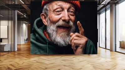 Portrait of bearded old man in orange hat with wrinkled weathered face and tired experienced eyes expressing positivity and joy, posing isolated over black background. Human emotions concept. Wall mural