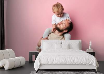 single parebt family. close up photo, isolated pink background, rlation between father and son Wall mural