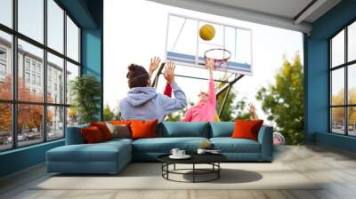 slam dunk. young caucasian basketball players, boys throwing ball into basketball hoop at playground. summer days, holidays Wall mural