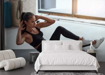 Slim sporty girl in sportswear pumping press lying on mat in gym. Window background Wall mural