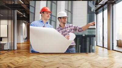 two builders are looking the area where the construction will be located. men chooses the area for building. side view photo Wall mural