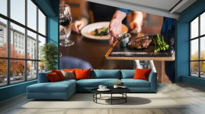 Waiters carrying plates with meat dish at a wedding Wall mural