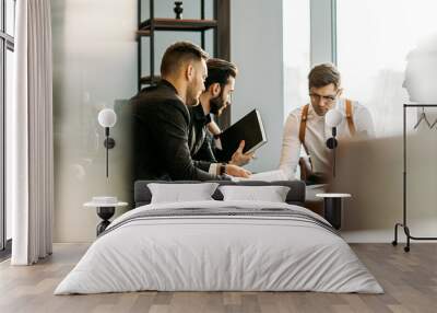 young caucasian business people, handsome guys in elegant stylish tux at meeting, hold conference for discussing new startup business project. success depends on teamwork and cohesion Wall mural