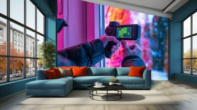 Man holds a thermal imager and points it at a window where a heat leak can be seen Wall mural