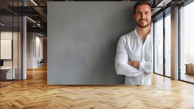 Man standing confidently against a plain grey background Wall mural