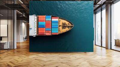 Aerial view of a large cargo ship carrying numerous colorful shipping containers sailing on a vast blue ocean, highlighting global trade and transportation. Wall mural