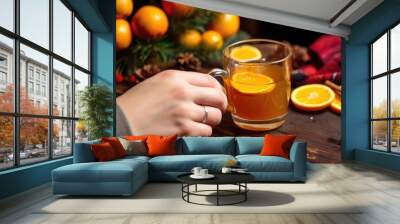 hand placing an orange slice into a cup of mulled cider Wall mural