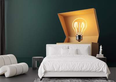 Illuminated light bulb inside an open cardboard box against a dark green background, symbolizing new ideas and creativity. Wall mural