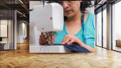 Young woman at her sewing machine Wall mural