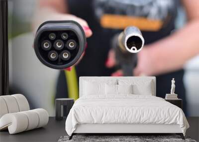 Fuel nozzle and electric car charger plug. EV vs gasoline. Wall mural