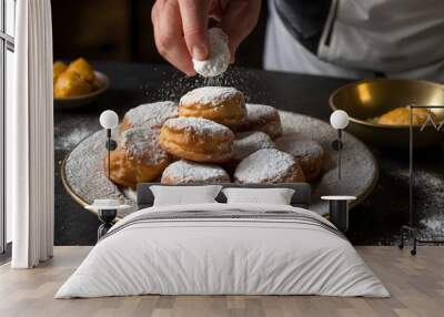 A closeup image of a chef sprinkling powdered sugar over a plate of beignets The beignets are golden brown and look delicious. generative AI Wall mural