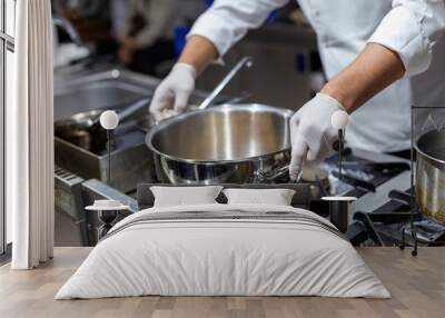 A cook stirring pots in the kitchen. Big pots in the kitchen Wall mural