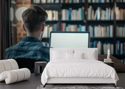 laptop mockup over shoulder shot of a young man using laptop with blank white screen for mockup  Wall mural