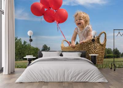 Baby Girl in a Basket with Red Balloons Wall mural