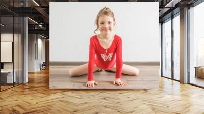 Flexible little girl in red leotard doing gymnastic Wall mural