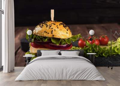 Homemade vegetarian burger with cutlet, tomato, cheese, green salad and purple onion on a dark wooden background Wall mural