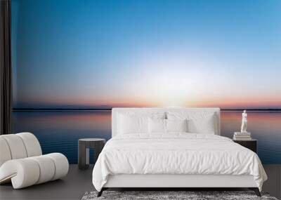 beautiful, red dawn on the lake. the rays of the sun through the fog. the blue sky over the lake, th Wall mural