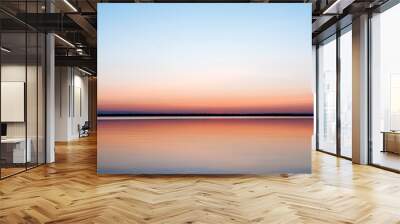 Beautiful, red dawn on the lake. The rays of the sun through the fog. The blue sky over the lake, the morning comes, the sky is reflected in the water. Wall mural