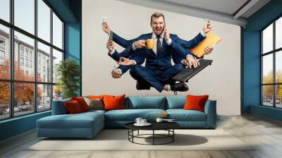 Businessman with many hands in a suit. Works simultaneously with several objects, a mug, a magnifying glass, papers, a contract, a telephone. Multitasking, efficient business worker concept. Wall mural