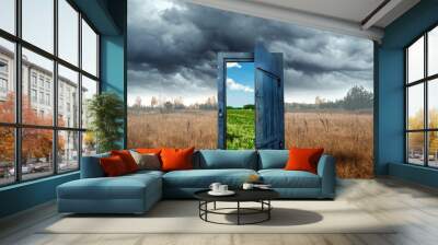 Creative background. Old wooden door, blue color, in the box. Transition to a different climate. The concept of climate change, portal, magic. Copy space. Wall mural