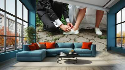 man ties the shoes to the bride. The concept of marriage, family relationships, wedding paraphernalia. Wall mural