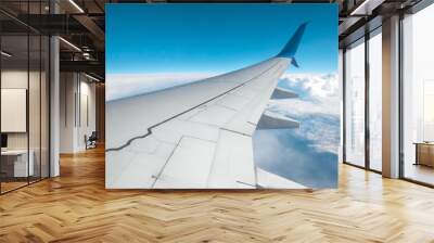 View from the window of a passenger plane above the clouds. International cargo transportation, air travel, transport, air travel, vacations. Copy space. Wall mural