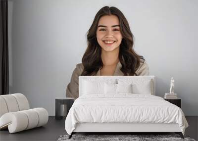 A woman with long brown hair is smiling and wearing a tan jacket Wall mural