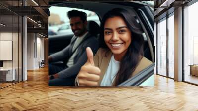 Beautiful young latin woman driving her brand new car and showing her thumb up Wall mural