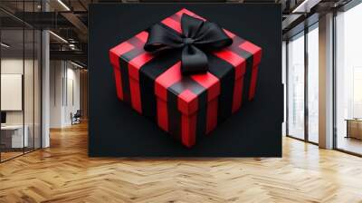 Gift box wrapped in red striped paper with black bow on dark background for Black Friday sale Wall mural