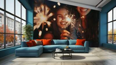 Two women are holding lit sparklers and smiling Wall mural