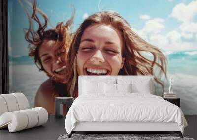 Two women are smiling and laughing on a beach Wall mural