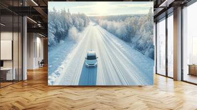 White car driving on winding road through snowy forest, sun light. Concept winter travel, aerial view Wall mural