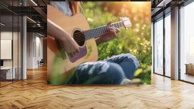 Woman playing acoustic guitar sitting in grass outdoors showcasing music in nature summertime relaxation and artistic expression Wall mural