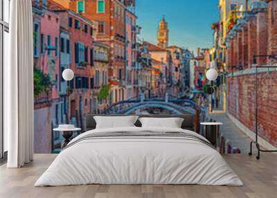 Venice cityscape with narrow water canal and colorful boats moored near fondamenta embankment, Veneto Region, Northern Italy. Typical Venetian view at sunset, vertical view, blue sky background Wall mural