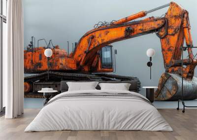 A massive orange excavator with detailed machinery, ready for heavy-duty industrial tasks in snowy conditions Wall mural