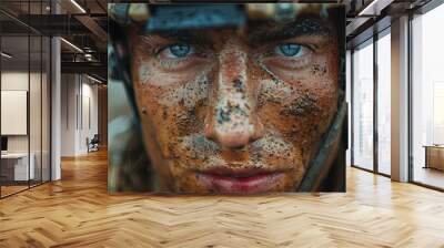 Portrait of a man in a military helmet with a dirty face Wall mural