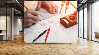 engineering drawing of the scheme of automatic heat supply, top side view with male hands, screwdriver, pencil and multi meter Wall mural