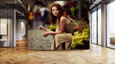 beautiful red-haired woman resting on the streets of the beautif Wall mural