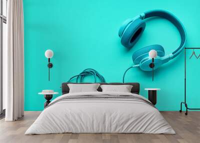 Turquoise headphones a colored background. Music concept with copyspace. Blue headphones isolated Wall mural