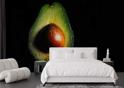   A close-up of an avocado with water droplets on its skin and a piece of fruit in the foreground Wall mural