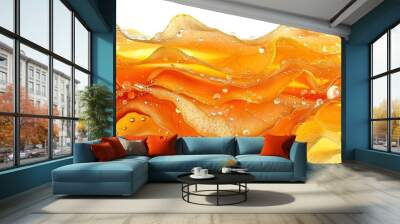   A close-up view of a yellow and orange wave of liquid on a white background, with droplets of water at its base Wall mural